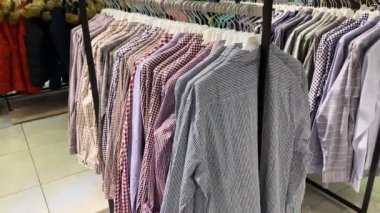 Yakın plan: elbise askısı. Elbise askıları. Alışveriş merkezinde sıradan kıyafetleri olan askılar. Tasarımcı giysi koleksiyonu. Moda mağazasında yeni koleksiyon. İnsan kavramı yok.