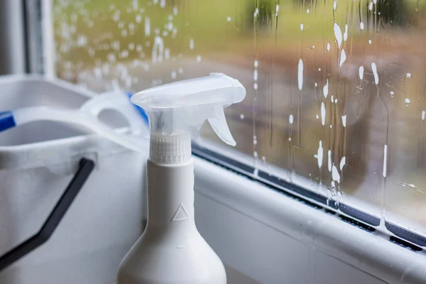 Window cleaning detergent. Washing the glass on the windows with cleaning spray. Selective soft focus. Empty place for text, copy space