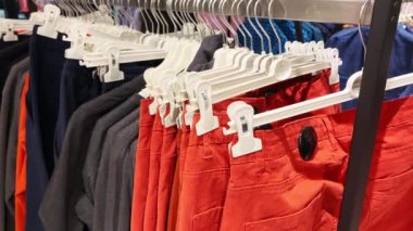 Yakın plan: elbise askısı. Elbise askıları. Alışveriş merkezinde sıradan kıyafetleri olan askılar. Tasarımcı giysi koleksiyonu. Moda mağazasında yeni koleksiyon. İnsan kavramı yok