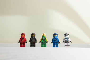 Polonya - 15 Mayıs 2022: Lego Ninjago Minyatürlerinin Portresi. Şehir ve arka plandaki insanlar. Lego Ninjago 'nun küçük yeşil ninjalarının editörel çizimi.