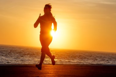 gün batımında okyanus manzaralı çalışan kadın