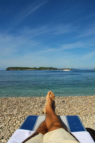 Uomini che si rilassano al mare in spiaggia rocciosa — Foto Stock