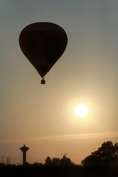 Hete lucht ballon opstijgen in zonsopgang — Stockfoto