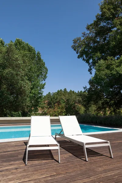 Biały leżakami basenie z drzewami w tle — Zdjęcie stockowe