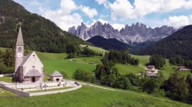 Relaxing drone view of St Maddalena in green Vall de Funes, Dolomites