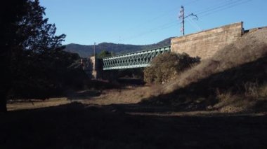 Aerial footage of an iron railroad bridge located in the Depeaperros line from Seville to Alcazar de San Juan in Spain. A perfect example of ancient railroad structure that nowadays is still in use