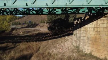 Aerial footage of an iron railroad bridge located in the Depeaperros line from Seville to Alcazar de San Juan in Spain. A perfect example of ancient railroad structure that nowadays is still in use