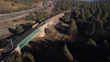 Aerial footage of an iron railroad bridge located in the Depeaperros line from Seville to Alcazar de San Juan in Spain. A perfect example of ancient railroad structure that nowadays is still in use