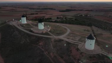 Drone footage of four windmills taken at sunset in 4k. This is a typical scenery in Castilla La Mancha, the central region os Spain