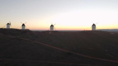Drone footage of four windmills taken at sunset in 4k. This is a typical scenery in Castilla La Mancha, the central region os Spain