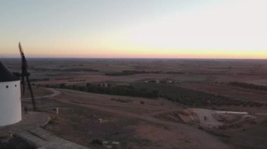 Drone footage of four windmills taken at sunset in 4k. This is a typical scenery in Castilla La Mancha, the central region os Spain