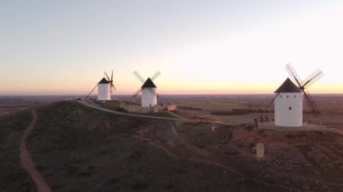 Drone footage of four windmills taken at sunset in 4k. This is a typical scenery in Castilla La Mancha, the central region os Spain