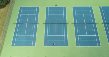 İki tenisçi yaz aylarında parktaki tenis kortunda birbirlerine karşı yarışıyorlar..