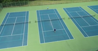 İki tenisçi yaz aylarında parktaki tenis kortunda birbirlerine karşı yarışıyorlar..