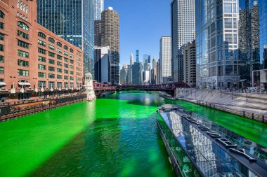 Odyssey Şikago Nehri, iklim kontrollü, cam kaplı bir yemek gemisi, St. Patrick Günü 'nü kutlamak için nehrin yıllık boyaması sırasında Chicago Nehri' ni dolaşır..