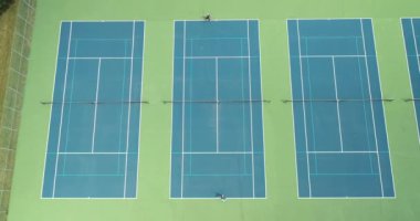 İki tenisçi yaz aylarında parktaki tenis kortunda birbirlerine karşı yarışıyorlar..