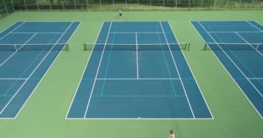 İki tenisçi yaz aylarında parktaki tenis kortunda birbirlerine karşı yarışıyorlar..