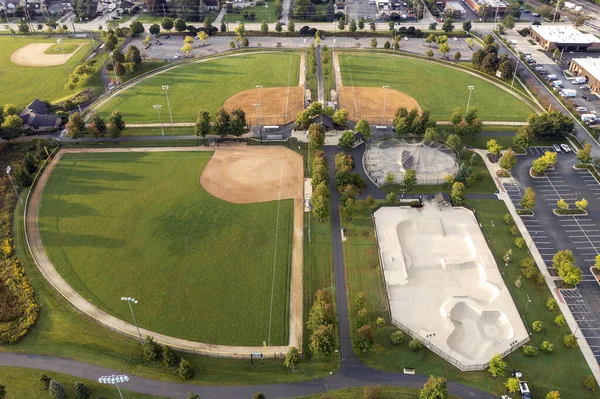 一个有棒球 垒球钻石 溜冰场和击球笼的体育场的空中景观 — 图库照片