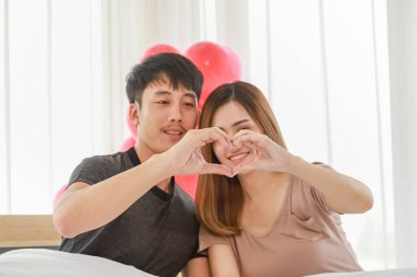 İnsanlar, Aşk ve Çift Konsepti. Genç Asyalı kadın ve erkeğin yatak odasında el ele tutuşup el hareketi yapmalarına yakın durun..