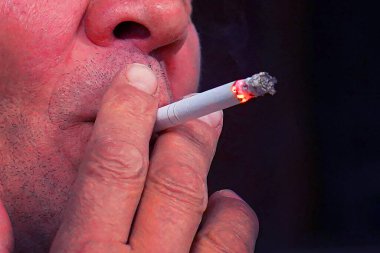 Sigara içen yakın plan bir adam. Sigara içen yaşlı bir adam