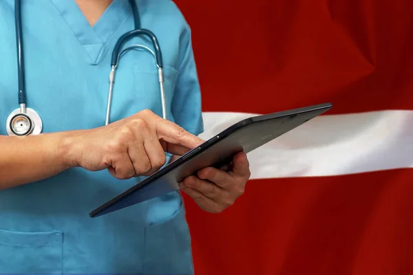Kirurg Eller Läkare Som Använder Digital Tablett Bakgrunden Lettlands Flagga — Stockfoto