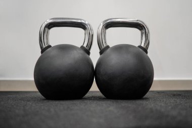 Spor salonunda arka arkaya siyah çaydanlık. Farklı ağırlıklarda birkaç siyah ağırlık. Black Metal bir sıra ağırlık kaldırıyor. Spor kulübünde çaydanlık. Ağırlık Çalışması Ekipmanı