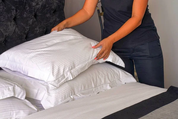 Otel odasında yatağı toplayan genç kadın hizmetçinin eli. Temizlikçi Yatağı Yapıyor