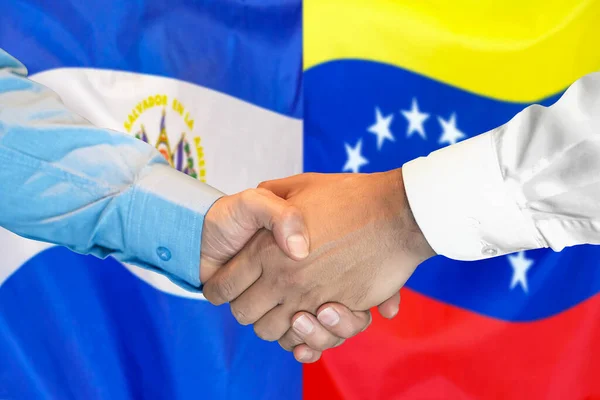 在两面旗帜的背景下进行商业握手 男子在萨尔瓦多和委内瑞拉国旗的背景下握手 支助概念 — 图库照片