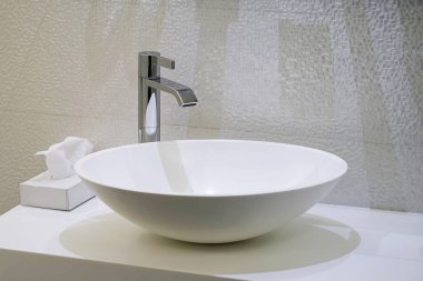 Lavabo ve musluğu olan bir banyo. Lüks otellerde modern tasarımla banyo içi lavabo.