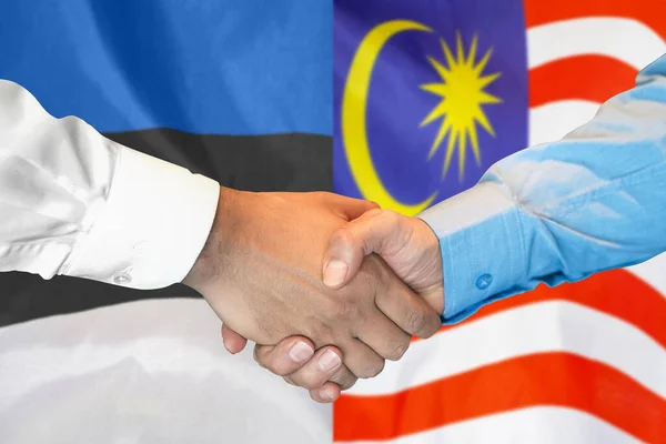 在两面旗帜的背景下进行商业握手 男子在爱沙尼亚和马来西亚国旗的背景下握手 支助概念 — 图库照片