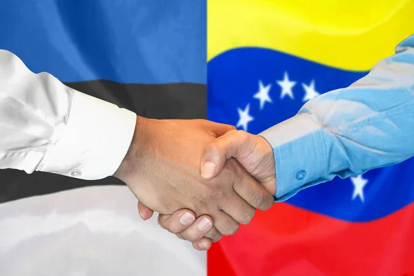 在两面旗帜的背景下进行商业握手 男子在爱沙尼亚和委内瑞拉国旗的背景下握手 支助概念 — 图库照片