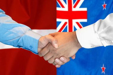 Business handshake on background of two flags. Men handshake on background of New Zealand and Latvia flag. Support concept