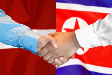 İki bayrağın arka planında iş tokalaşması. Kuzey Kore ve Letonya bayrağının arka planında erkek tokalaşması. Destek konsepti