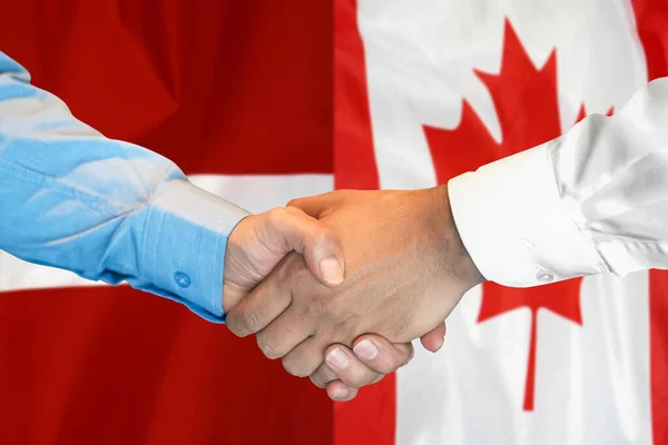 在两面旗帜的背景下进行商业握手 男子握手背景加拿大和拉脱维亚国旗 支助概念 — 图库照片