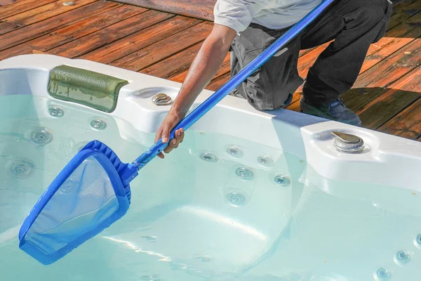 Hand of african maintenance hotel staff worker cleaning hot tub