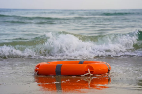 海での生命リング 砂の上の赤い救命ブイ 砂の上にオレンジの生命保存器 — ストック写真