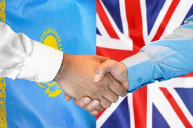 İki bayrağın arka planında iş tokalaşması. Kazakistan ve İngiliz bayrağının arka planında erkek tokalaşması. Destek konsepti