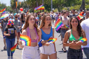 Tel Aviv 'deki Hoşgörü Yürüyüşü' nde gökkuşağı bayraklı üç genç kız. Geleneksel LGBT geçit töreni. 10 Haziran 2022. Tel Aviv 'de. İsrail