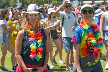 İki yaşlı lezbiyenin portresi bir grup insanın arka planına karşı hoşgörü geçidinde. Geleneksel LGBT geçit töreni. Gay onur yürüyüşünde gökkuşağı bayrakları. 10 Haziran 2022. Tel Aviv 'de. İsrail