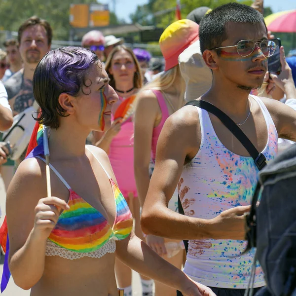 Hoşgörü geçidinde gökkuşağı pastalı genç bir çift kalabalığın arka planına karşı. Geleneksel LGBT geçit töreni. 10 Haziran 2022. Tel Aviv 'de. İsrail