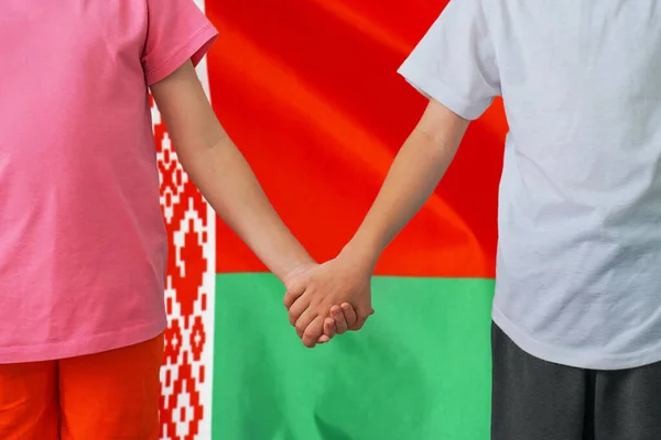 Two children joined hands on flag Belarus background. Boy and girl joined hands on background flag of Belarus. Concept of family and parenting in Belarus