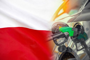 Polonya 'nın arka planında yakıt enjektörü olan bir araba. Nüfus için rekor fiyatlar yakıt. Polonya 'da enerji ve akaryakıt krizi sırasında benzin fiyatlarında artış