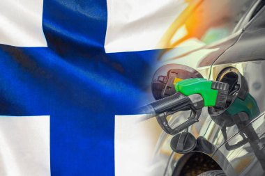 Finlandiya 'da arkaplanda yakıt enjektörü olan bir araba. Nüfus için rekor fiyatlar yakıt. Finlandiya 'da enerji ve akaryakıt krizi sırasında benzin fiyatlarında artış