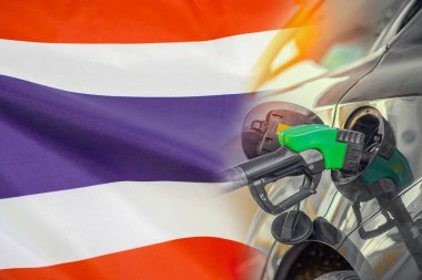Tayland bayrağı arkaplanında yakıt enjektörü olan bir araba. Nüfus için rekor fiyatlar yakıt. Tayland 'daki enerji ve akaryakıt krizi sırasında benzin fiyatlarında artış