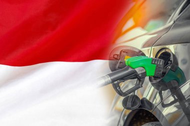 Endonezya bayrağı arkaplanda yakıt enjektörü olan bir araba. Nüfus için rekor fiyatlar yakıt. Endonezya 'daki enerji ve akaryakıt krizi sırasında benzin fiyatları arttı