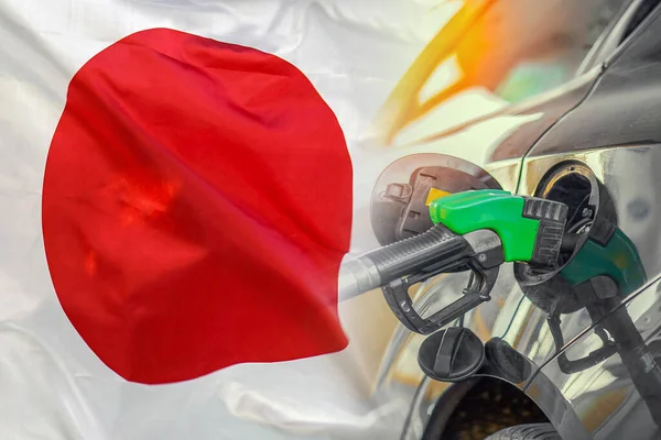 Car with a fuel injector on Japan flag background. Record prices fuel for population. Gasoline price increase during energy and fuel world crisis in Japan