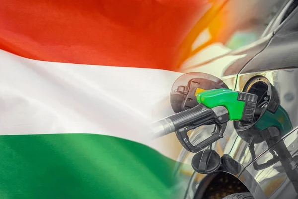 Car with a fuel injector on Hungary flag background. Record prices fuel for population. Gasoline price increase during energy and fuel world crisis in Hungary