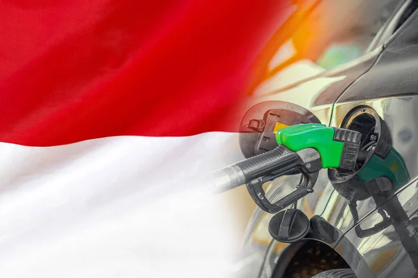 Car with a fuel injector on Indonesia flag background. Record prices fuel for population. Gasoline price increase during energy and fuel world crisis in Indonesia