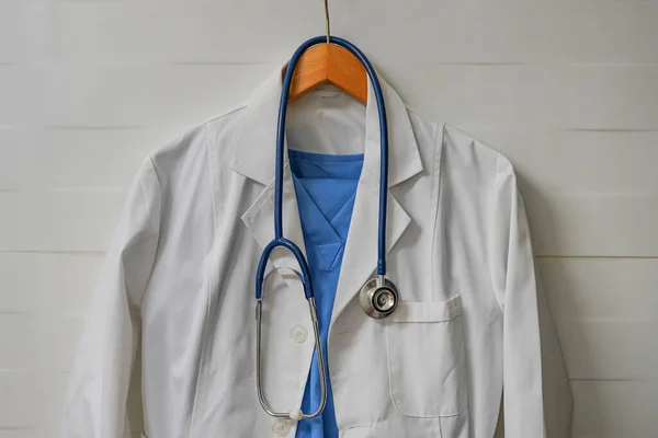 White Blue Smock Stethoscope Wooden Hanger Ceramics Wall Background Closeup — 스톡 사진