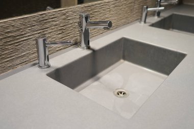 Interior of bathroom with washbasin and faucet. Public bathroom in the airport or restaurant, cafe. Bathroom interior sink with modern design in luxury hotel